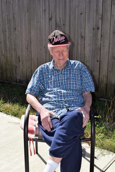 Senior man sitting outdoors in casual attire