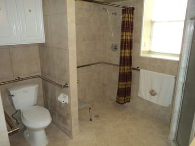 Accessible bathroom with grab bars and shower.