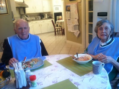 Two residents enjoying meals in a dining area