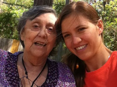 A staff member and a resident smiling outdoors
