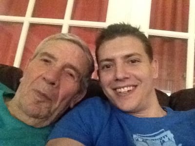 Two men smiling for a selfie in a cozy interior