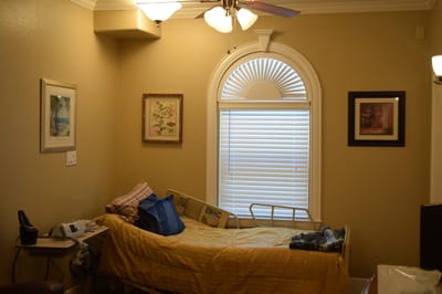 A private resident room with a bed and artwork