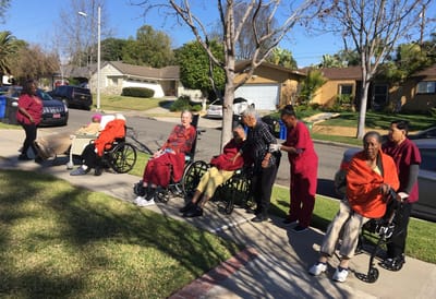 Residents in wheelchairs enjoying a sunny day outside