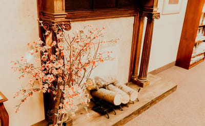 Decorative fireplace with logs and flower accents