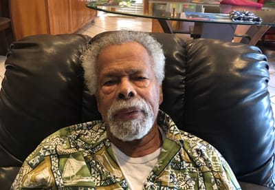 Resident relaxing in a living room chair