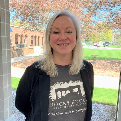 A staff member outside the facility in a branded shirt