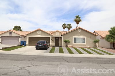 Exterior view of a senior living home with palm trees