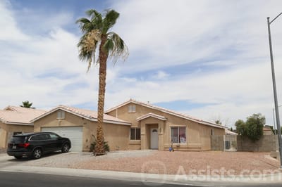 Exterior view of a residential care facility with palm trees