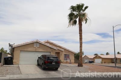 Exterior view of a residential care facility with a palm tree