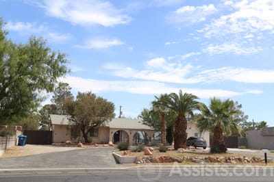 Exterior view of a senior care facility with palm trees