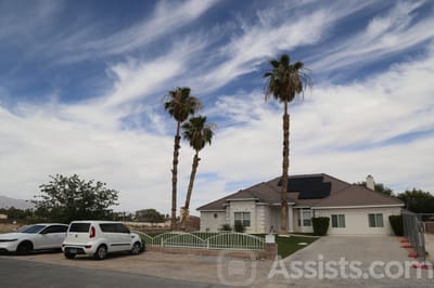 Exterior view of a senior living facility with palm trees