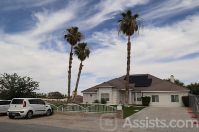 Exterior view of a senior living facility with palm trees