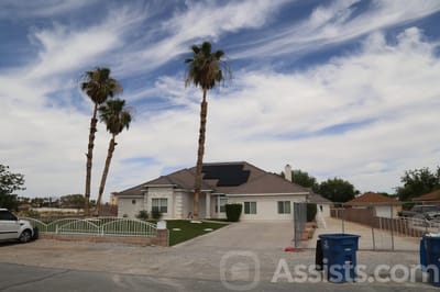 Exterior view of a senior living facility with palm trees