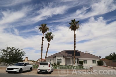 Exterior view of a senior living facility with palm trees
