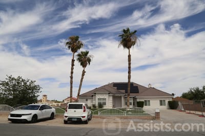 Exterior view of a senior living facility with palm trees
