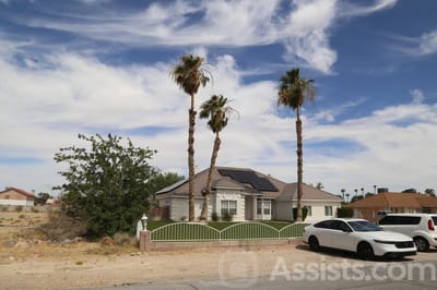 Exterior view of a senior living facility with palm trees