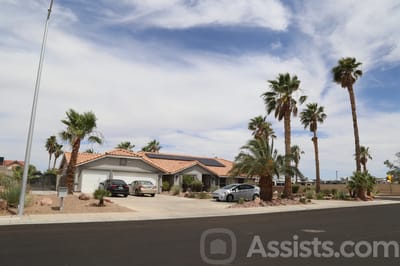 Exterior view of a residential-style senior facility with palm trees