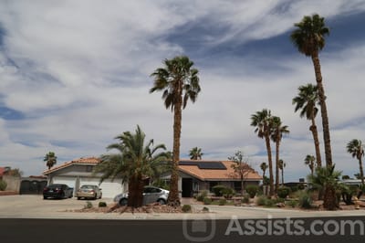 Exterior view of a senior living facility with palm trees