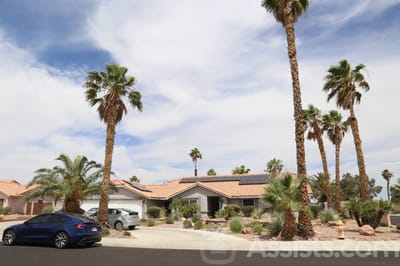 Exterior view of a senior living facility with palm trees