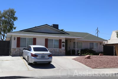 Front exterior of a residential care home with a car