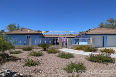 Exterior view of a blue assisted living facility with gardens