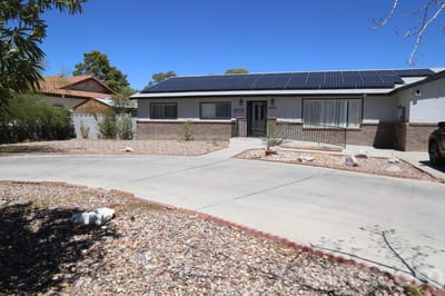 Exterior view of the facility with a driveway and solar panels