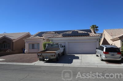 Exterior view of a home with a driveway and solar panels.