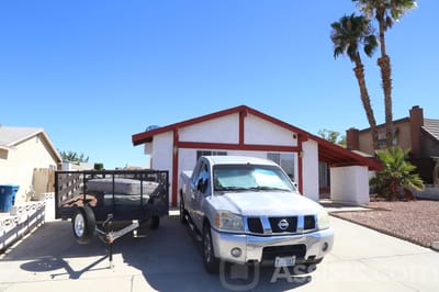 Exterior view of a residential building with a truck and trailer