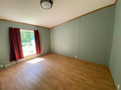 Empty resident room with a window and hardwood floor