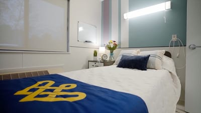 Brightly lit resident room with bedding and decor