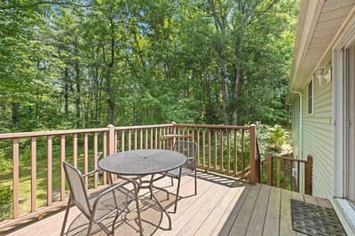 Outdoor deck with a table and chairs surrounded by trees