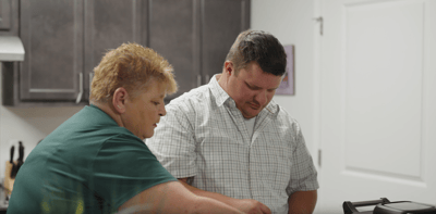 Staff assisting a resident in a kitchen setting