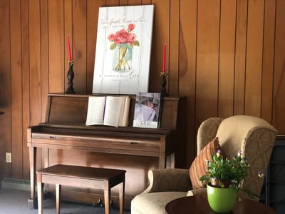 A cozy common area with a piano and decor
