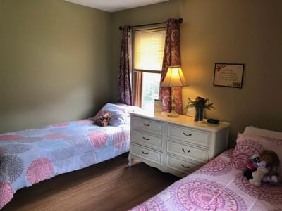 Cozy resident room with two beds and a dresser