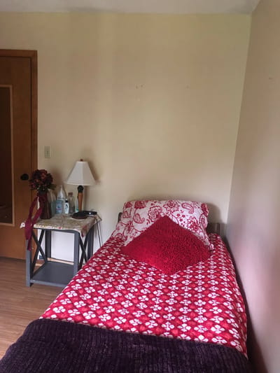 Cozy resident room with red bedding and decorative pillow