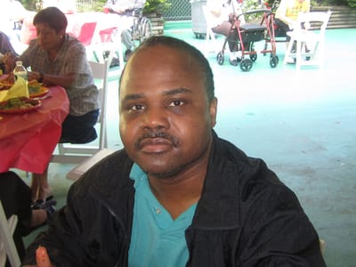 A resident enjoying a meal outdoors at a community event