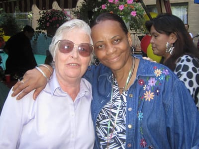 Two residents smiling together at a community event