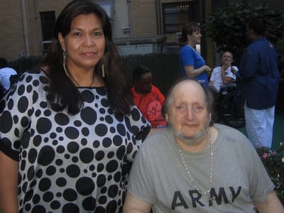 Resident and staff member posing together in outdoor space