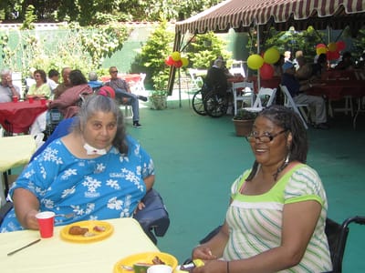 Residents enjoying a meal outside at a social event
