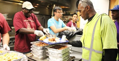 Staff serving food in a kitchen setting