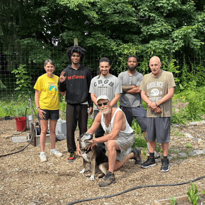Group of people in a garden with a dog