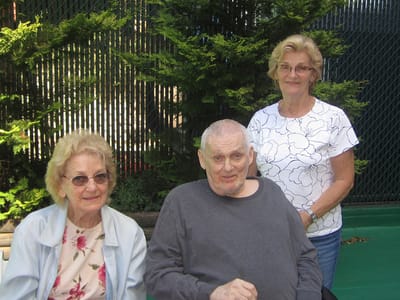 Three residents enjoying time outdoors in the facility's garden