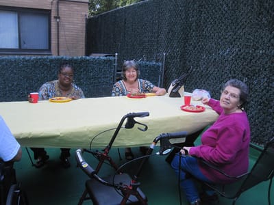 Residents enjoying a meal outdoors at a table