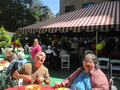 Residents enjoying a meal outdoors at a festive event
