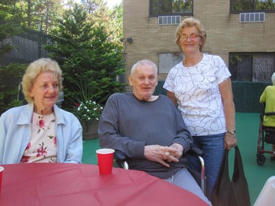 Residents enjoying time outdoors with tables and chairs