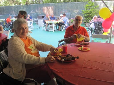 Residents enjoying a meal at an outdoor celebration.