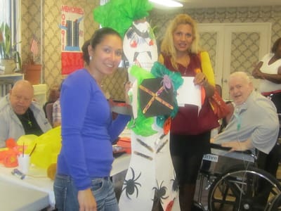 Two staff members and residents interacting during a crafts activity