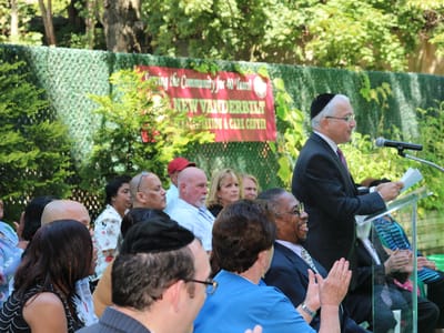 Outdoor event with residents and staff at a podium