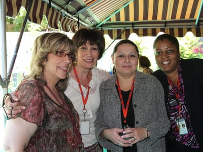 Four staff members smiling together outdoors
