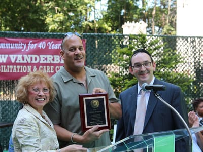 Residents and staff celebrating an award at an outdoor event
